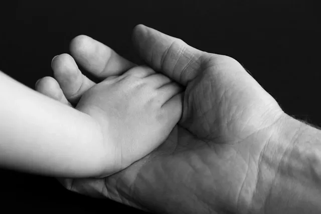 A parent is holding his kid's hand.