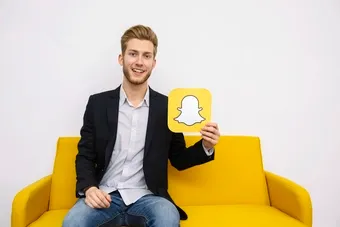 /a-man-holding-snapchat-logo