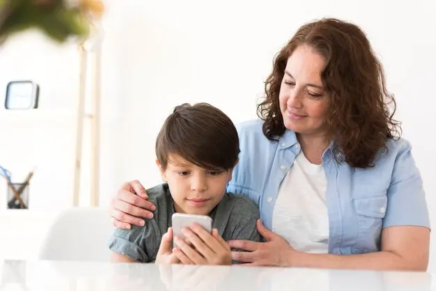 
Mère avec enfant regardant sur smartphone