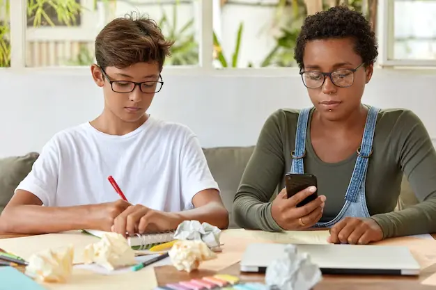 
Maman regarde le téléphone de son fils adolescent