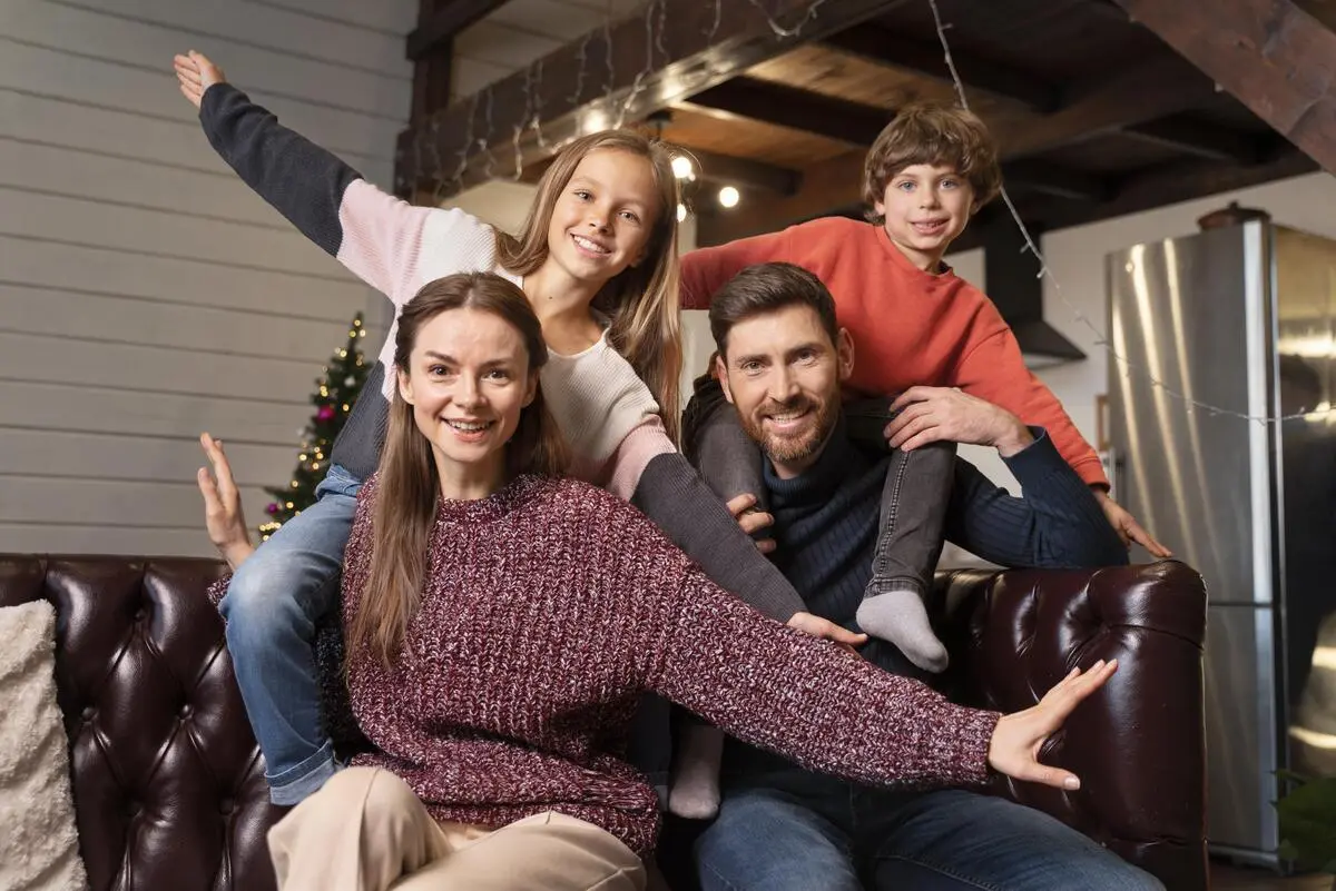 A family poses in front of a Christmas tree.